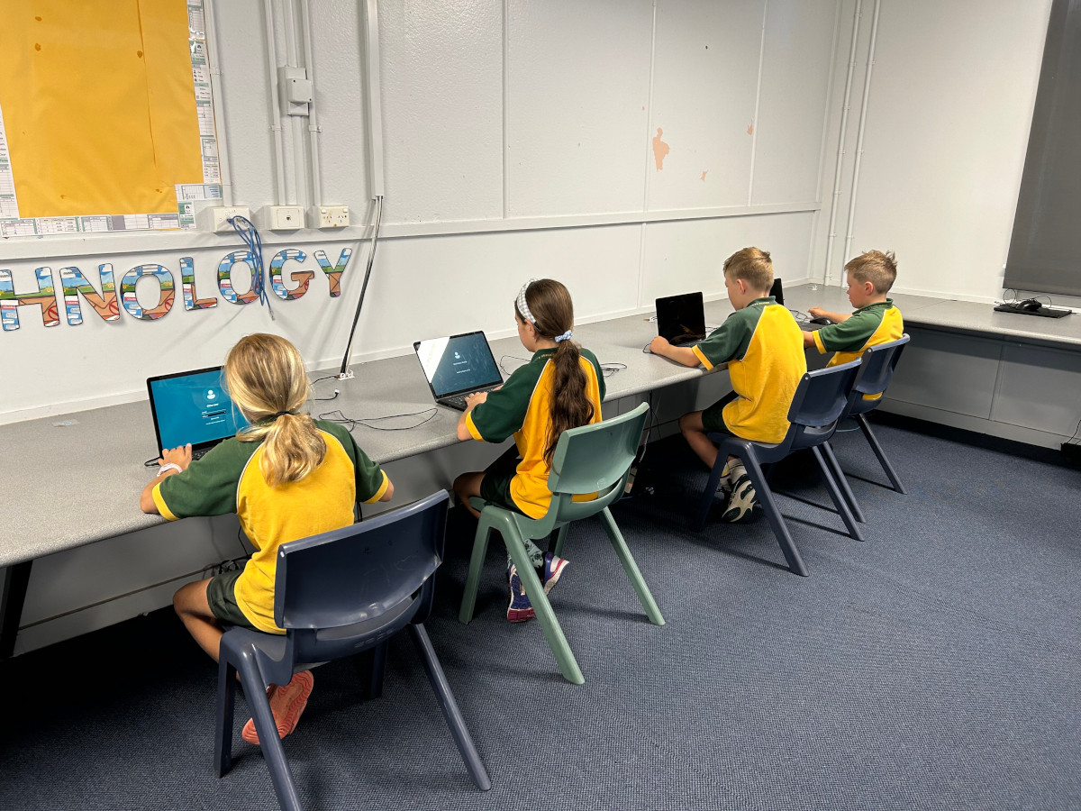 Students pictured in the primary school technology laboratory making use of their laptops.