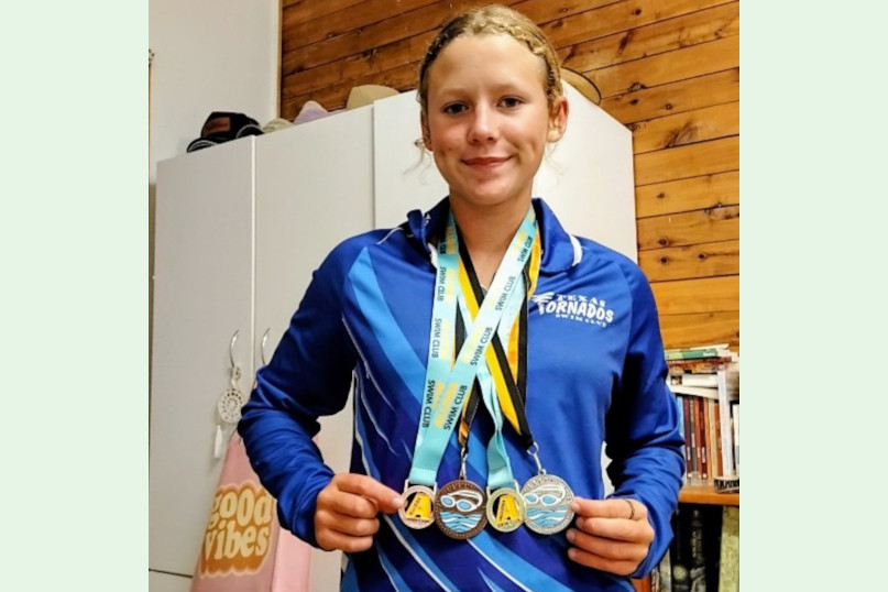Katie proudly wearing her swimming medals.
